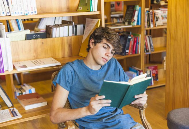male-teenager-reading-chair