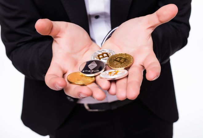 Young man isolated on white background holds bitcoin coin in his hands