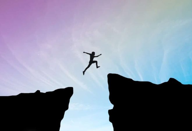 man-jump-through-the-gap-between-hill-man-jumping-over-cliff-on-blue-sky-business-concept-idea-1024x683