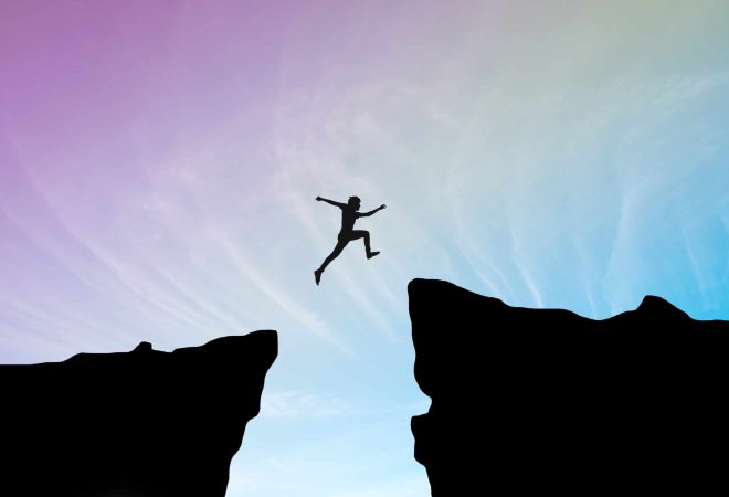 Man jump through the gap between hill.man jumping over cliff on blue sky ,Business concept idea