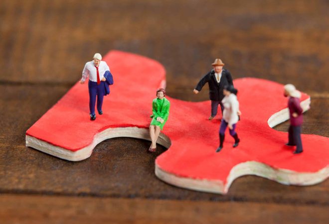 Conceptual image of miniature people on a jigsaw puzzle