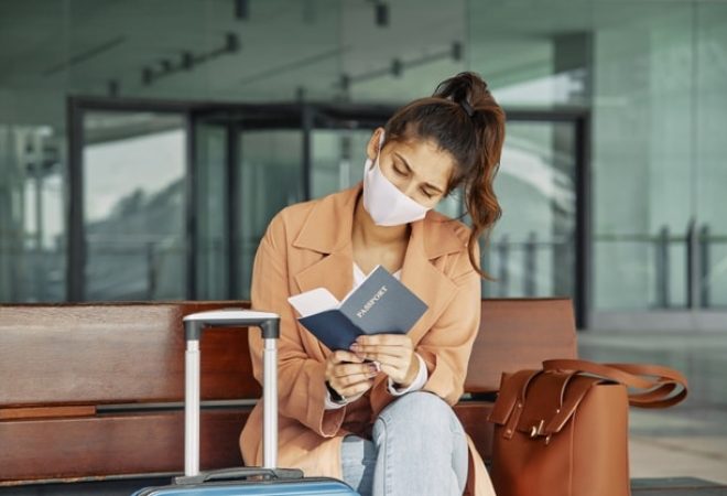 mulher-com-mascara-medica-verificando-seu-passaporte-no-aeroporto-durante-a-pandemia_23-2148789888