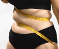 Obesity problems. Plus size female hate her body. Beauty standards and bands centimeter measuring tape. Insecure, needs healthy weight loss diet. Anonymous medium studio shot photo on white background