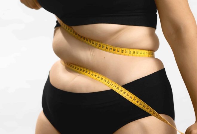 Obesity problems. Plus size female hate her body. Beauty standards and bands centimeter measuring tape. Insecure, needs healthy weight loss diet. Anonymous medium studio shot photo on white background