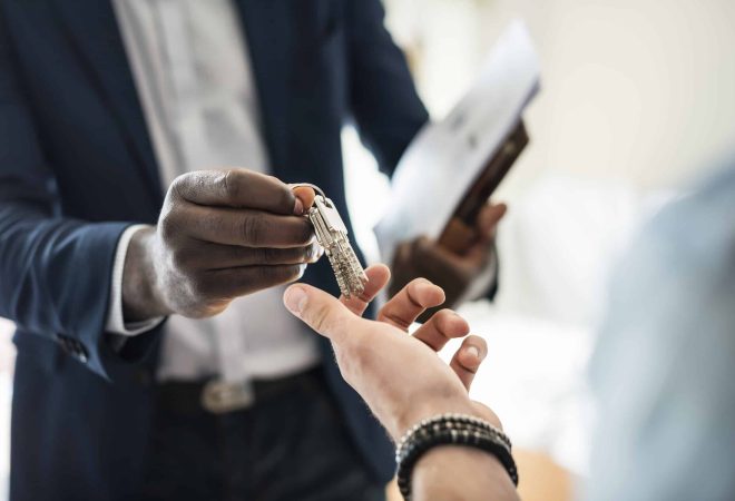 Real estate agent handing the house key to a client