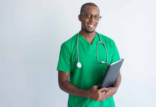 Portrait of successful young doctor with folder and stethoscope. African American general practitioner wearing glasses and green medical garment looking at camera and smiling. Medicine concept