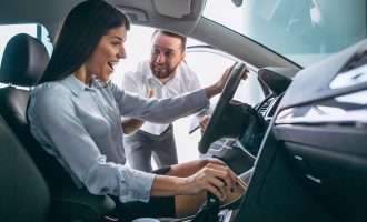 Salesman and woman looking for a car in a car showroom