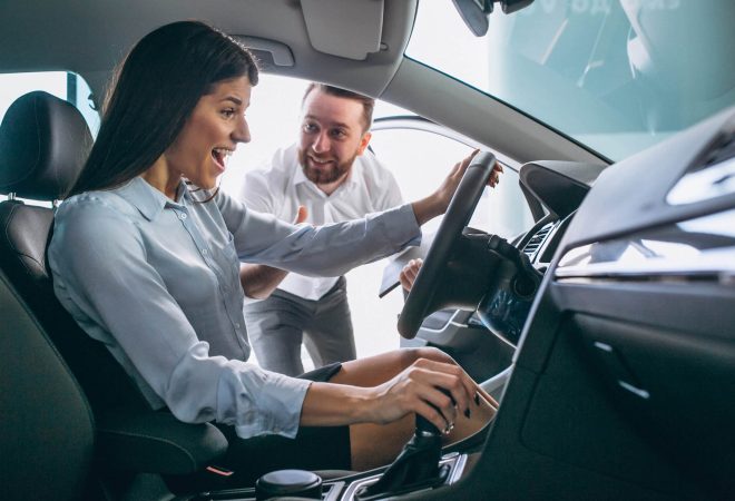 Salesman and woman looking for a car in a car showroom