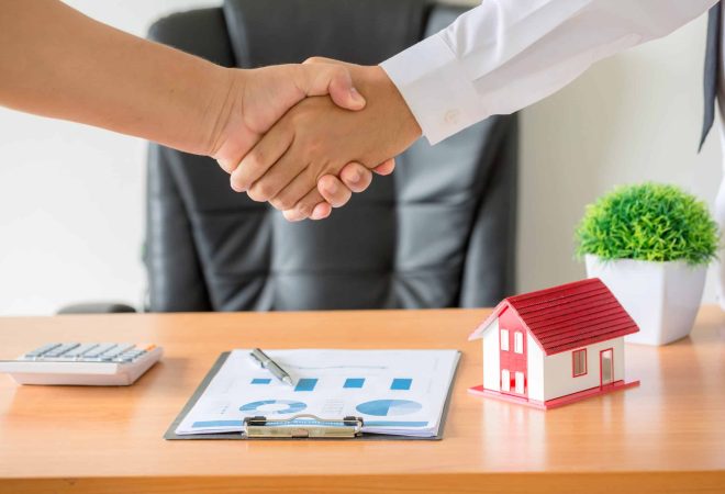 Side view hands of agent and client shaking hands after signed contract buy new apartment.
