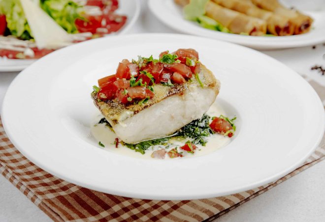 side view of baked seabass with tomatoes