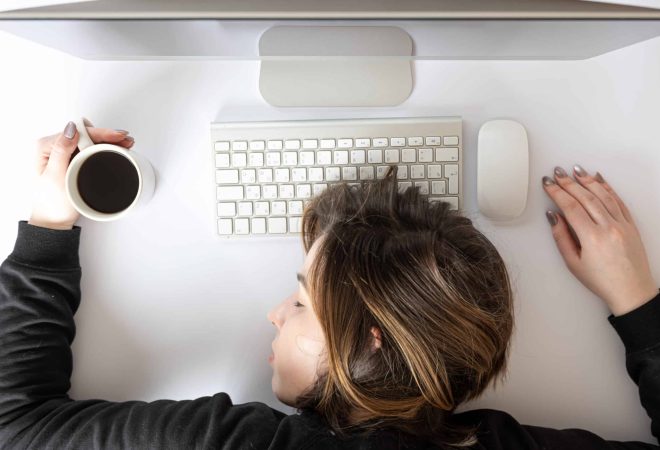 Flat lay, young woman sleeping in front of a computer, fatigue at work concept.