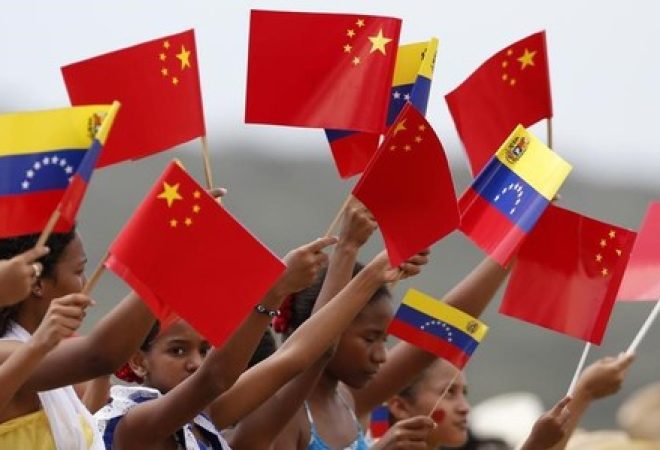 Crianças venezuelanas seguram bandeiras da China e da Venezuela para receber o presidente chinês, Xi Jinping, em Caracas