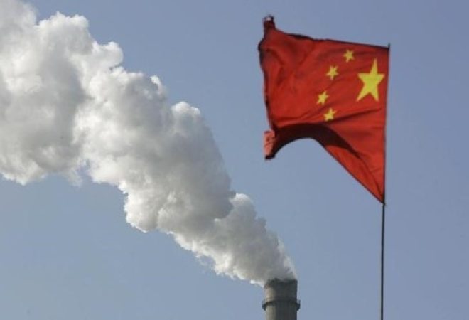 Bandeira da China vista em frente a chaminé de fábrica, em Taiyuan