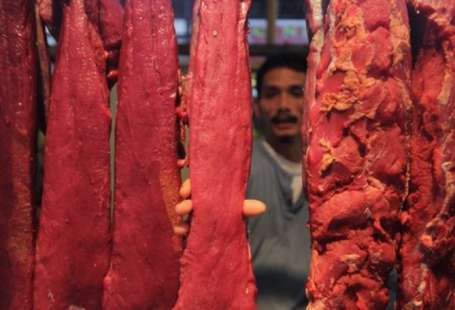 Homem segura pedaço de carne no mercado de Bumi Serpong Damai, em Tangerang, na província indonésia de Banten