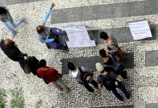 Pessoas observam lista de vagas de trabalho em São Paulo