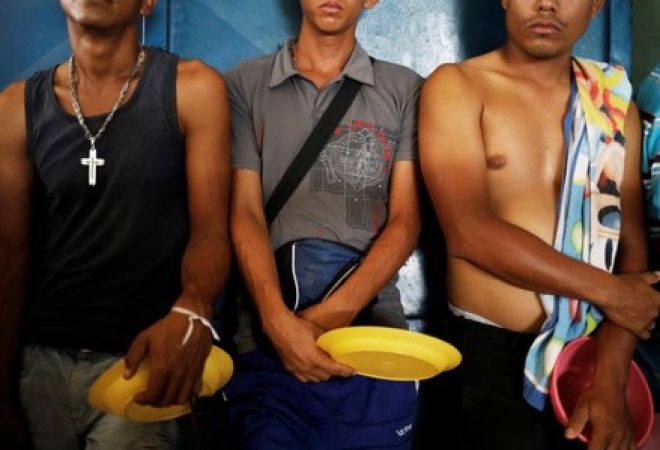Imigrantes venezuelanos alinhados para receber comida em abrigo em Boa Vista, Roraima, Brasil