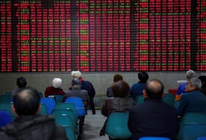 Investidor observa dados de ações em casa de corretagem em Xangai, na China