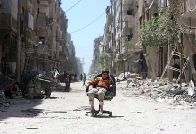 Menino em rua destruída na cidade síria de Douma