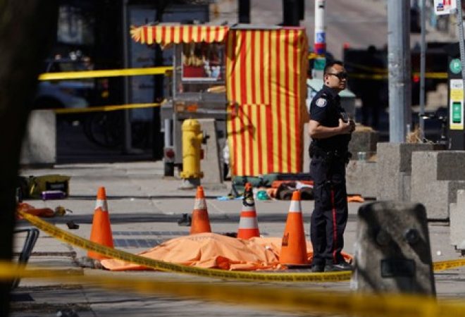 Policial ao lado de vítima no local em que van atingiu pedestres em Toronto, Canadá