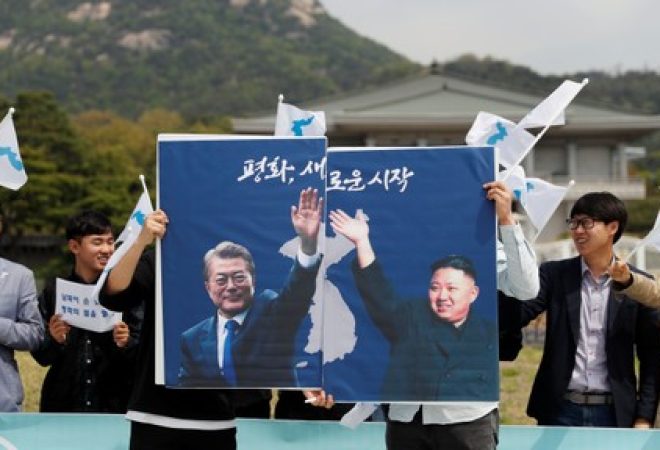 Estudantes seguram cartaz com líderes das Coreias em Seul