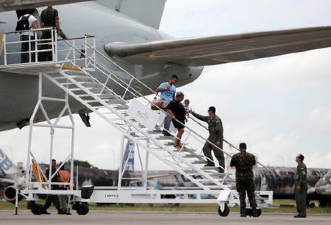Refugiados venezuelanos desembarcam de avião ao chegarem em aeroporto de Manaus