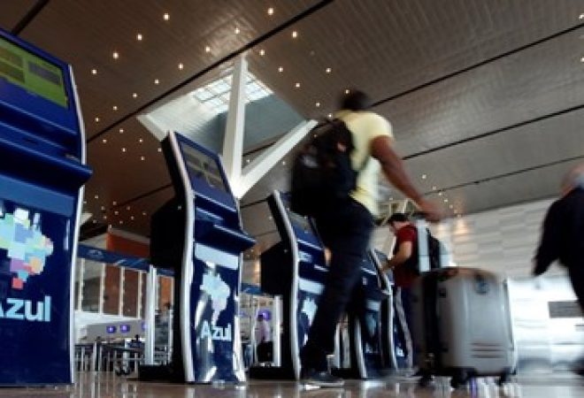 Pessoas passam por pontos de check-in online da Azul no aeroporto de Viracopos, em Campinas, Brasil