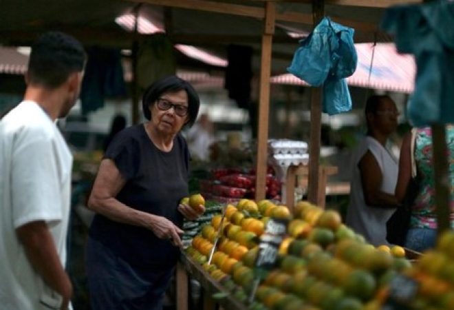 Mulher escolhe frutas em feira de rua noRio de Janeiro
