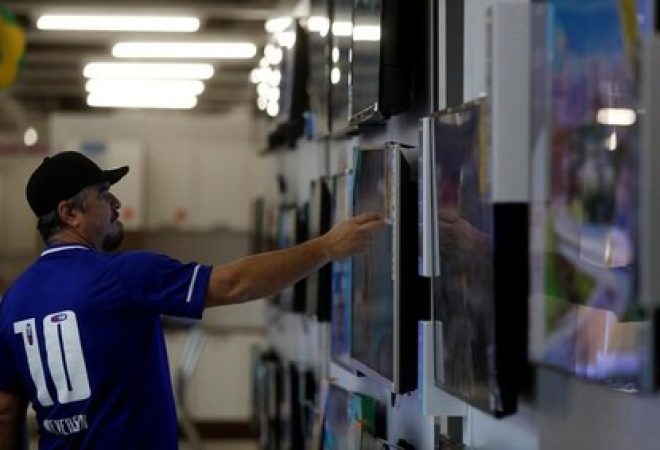 Homem checa preço de eletrônicos em loja em São Paulo