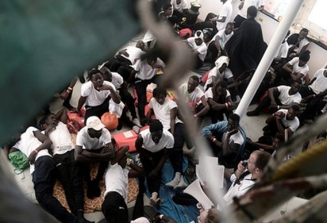Imigrantes no deque do MV Aquarius no mar Mediterrâneo
