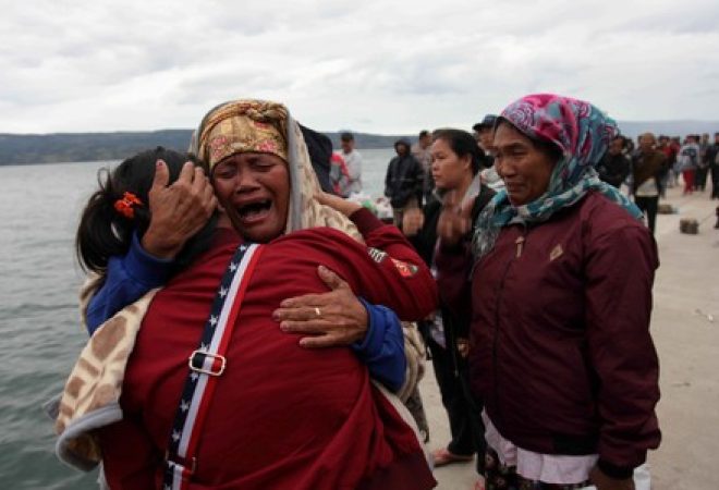 Familiares de passageiros de uma barca choram após naufrágio na Indonésia