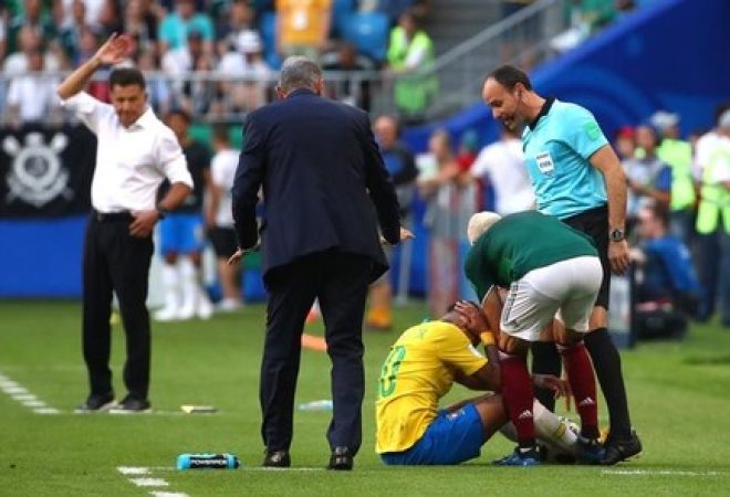 Neymar caído após sofrer falta, sendo observador pelos técnicos do Brasil e do México