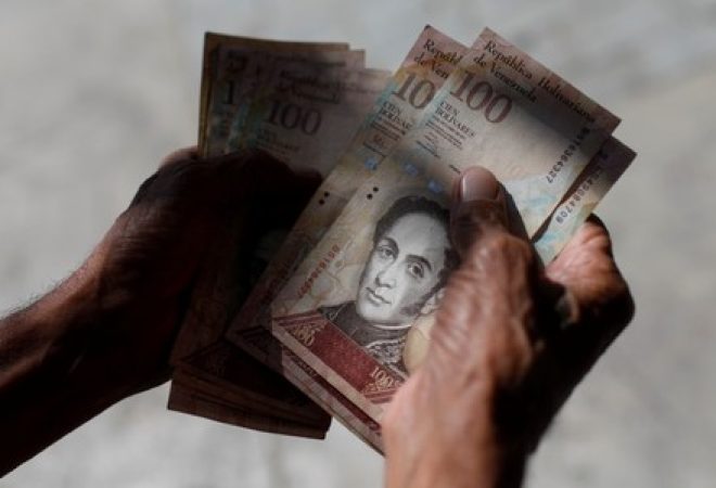 Venezuelano conta notas de bolívar no centro de Caracas
