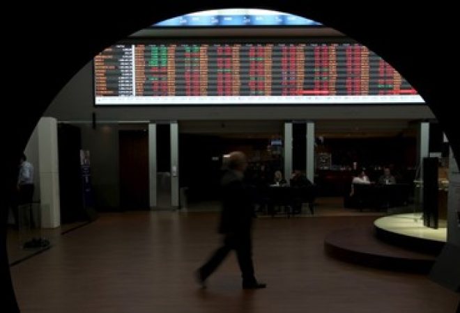 Homem passa por gráfico de cotações na Bovespa