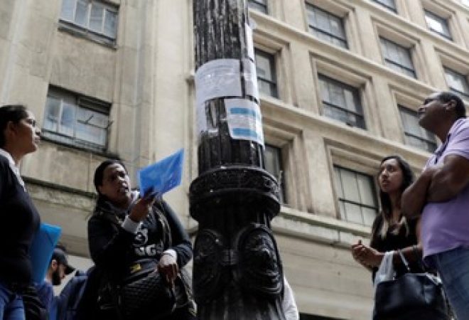 Pessoas leem anúncios de empregos em rua no centro de São Paulo