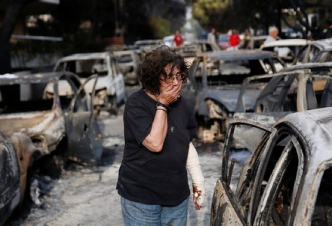 Mulher tenta encontrar seu cachorro após incêndio em Mati, perto de Atenas