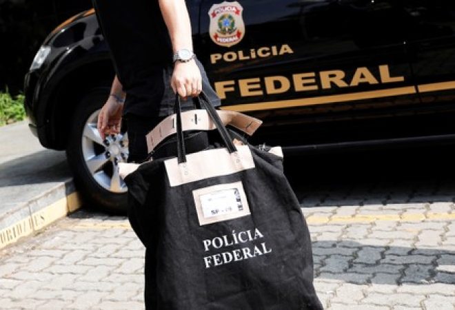 Policial federal carrega uma bolsa ao chegar à sede da Polícia Federal em São Paulo
