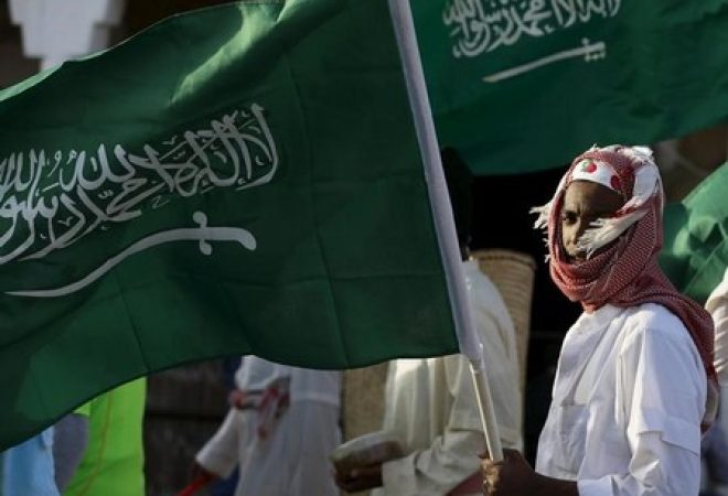 Homem segura bandeira saudita nos arredores de Riad, na Arábia Saudita