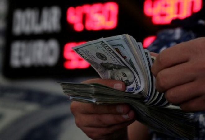 Pessoa manuseia notas de dólar