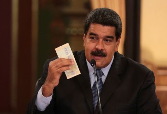 Presidente da Venezuela, Nicolás Maduro, segura nota da nova moeda do país, o bolívar soberano, durante reunião com ministros em Caracas