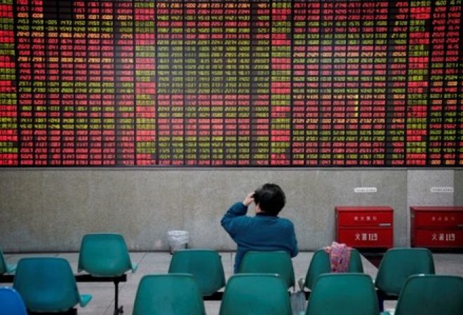 Investidor observa dados de ações em casa de corretagem em Xangai, na China