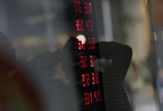 Pessoas são refletidas em vitrine de loja de câmbio no Rio de Janeiro, Brasil