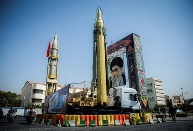 Reprodução de míssil é vista ao lado de foto do líder supremo do Irã, aiatolá Ali Khamenei, em praça em Teerã