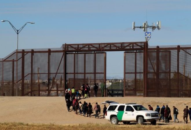 Imigrantes da América Central são escoltados por agente de fronteira dos EUA após se entregarem em El Paso, no Texas