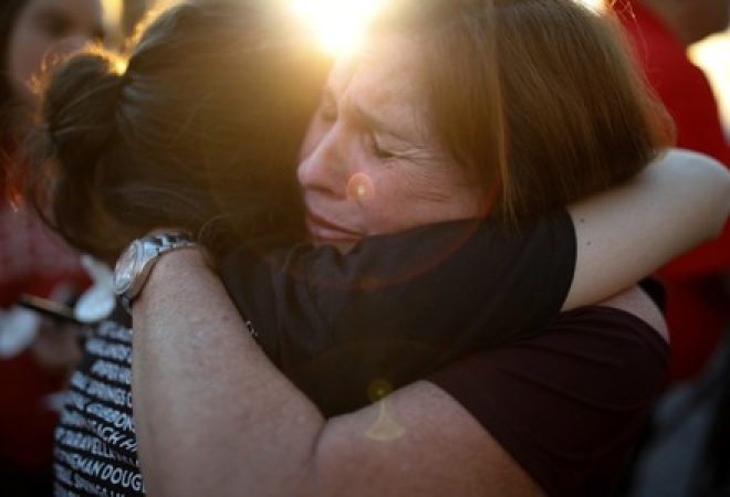 Mulheres reagem durante vigília para vítimas de incidente com tiros em escola na Flórida, Estados Unidos
