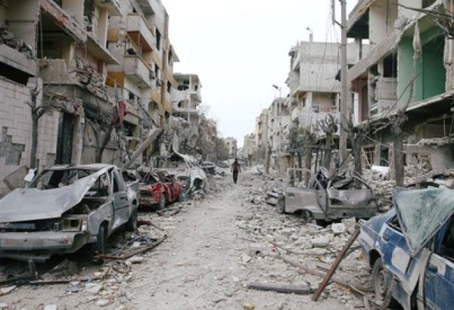 Carros e prédios danificados são vistos na cidade de Douma, em Ghouta Oriental, na Síria