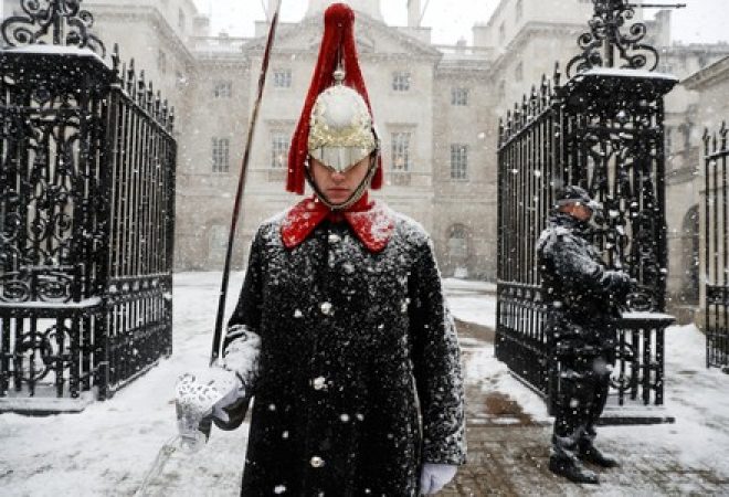 A guardsman stands on duty in the snow at Horse Guards Parade in London