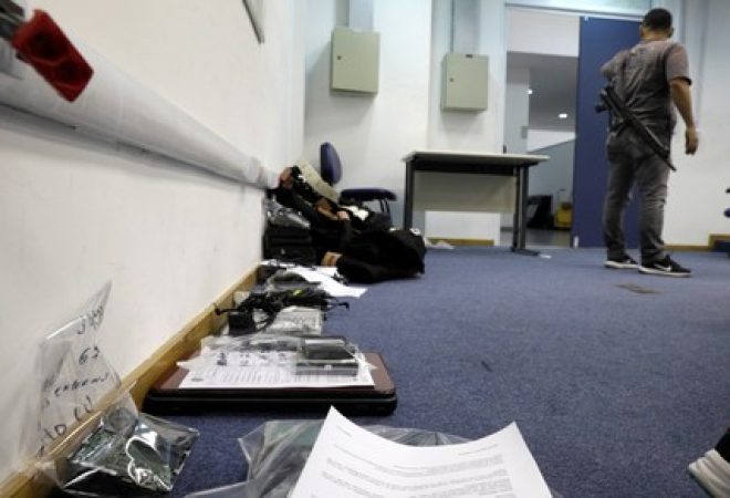 Policial perto de computadores apreendidos durante operação contra pedofilia, no Rio de Janeiro