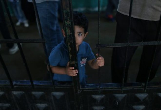 Menino palestino espera para viajar ao Egito pela travessia de fronteira de Rafah, na Faixa de Gaza