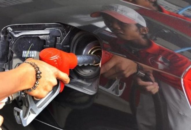 Trabalhador manuseia bomba de combustível
