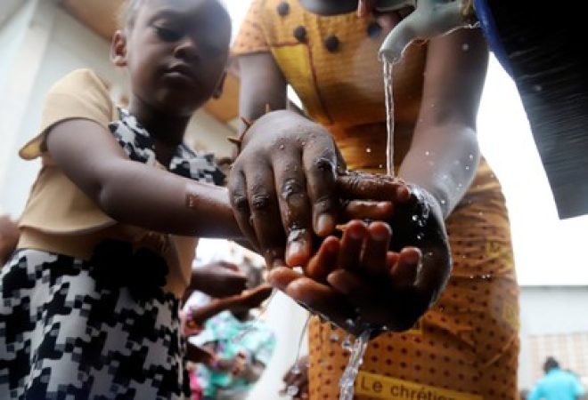 Criança congolesa lava a mão em medida de prevenção contra Ebola em Mbandaka